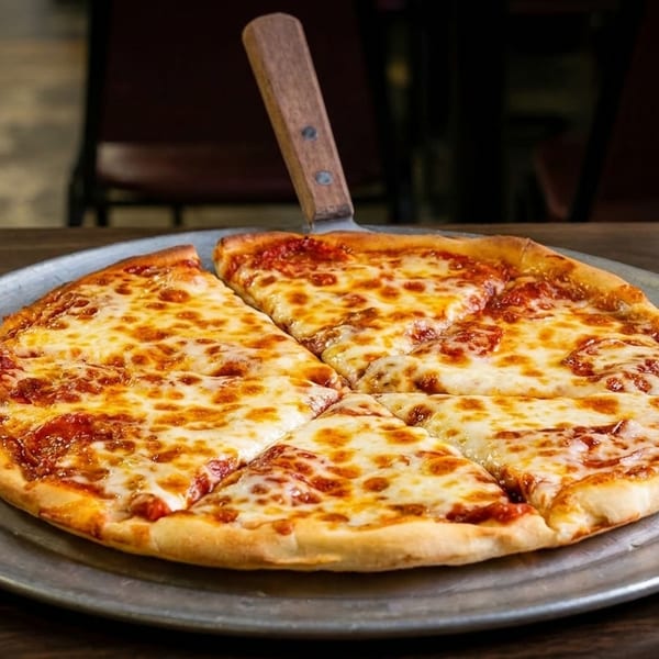 A freshly baked cheese pizza, sliced into six pieces, on a metal tray with a server.